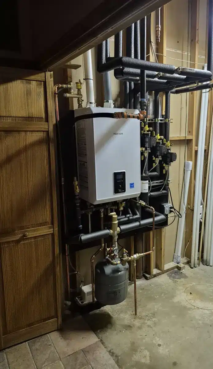 Wall-mounted Navien combination boiler with new near-boiler piping and expansion tank in a Milford, CT home, installed by Celco