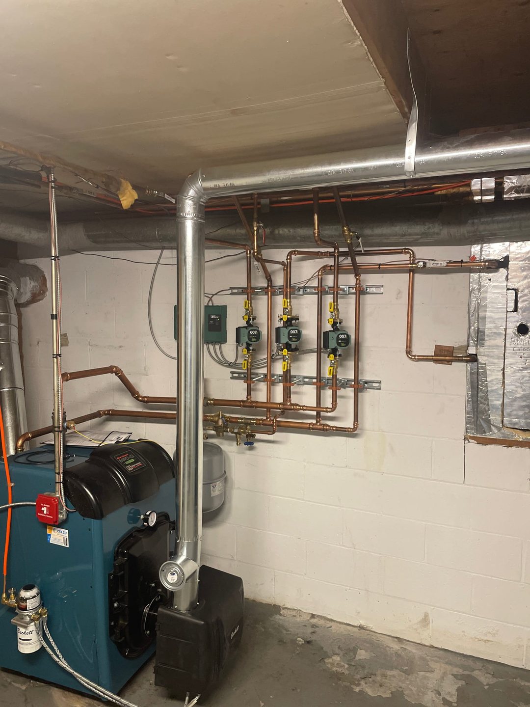 Burnham oil boiler with copper piping and circulators installed in a New Canaan home by Celco